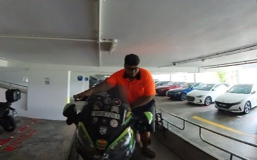 Orange Plus Towing crew member loading a sport bike onto the flatbed in a multi-storey carpark